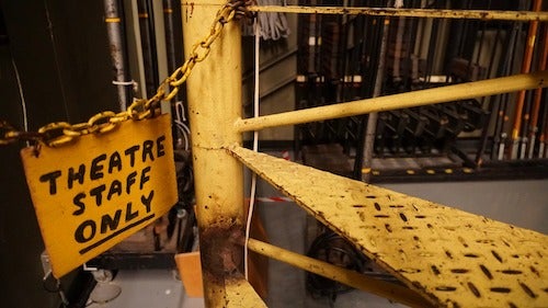 Backstage in the Humanities Theatre, with a "theatre staff only" sign blocking a circular stairwell.