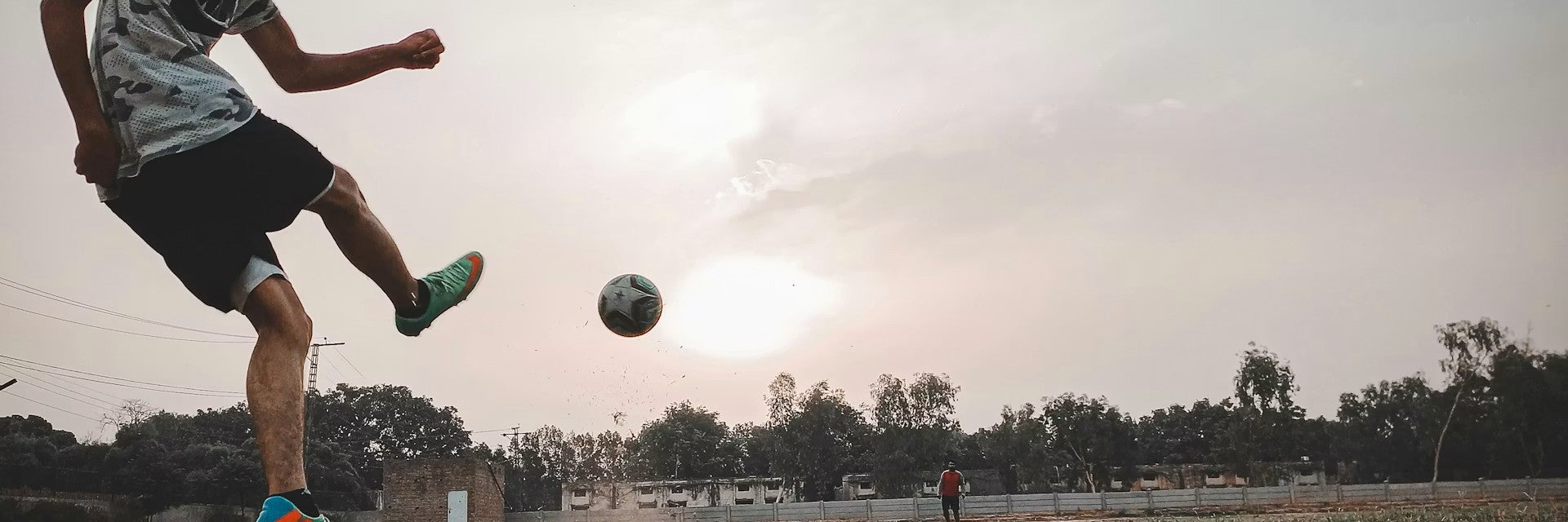 Youth kicking soccer ball in field
