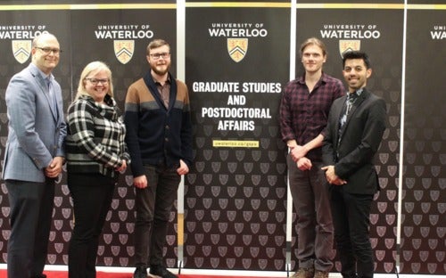 Gradflix contest winners standing in front of UWaterloo banners