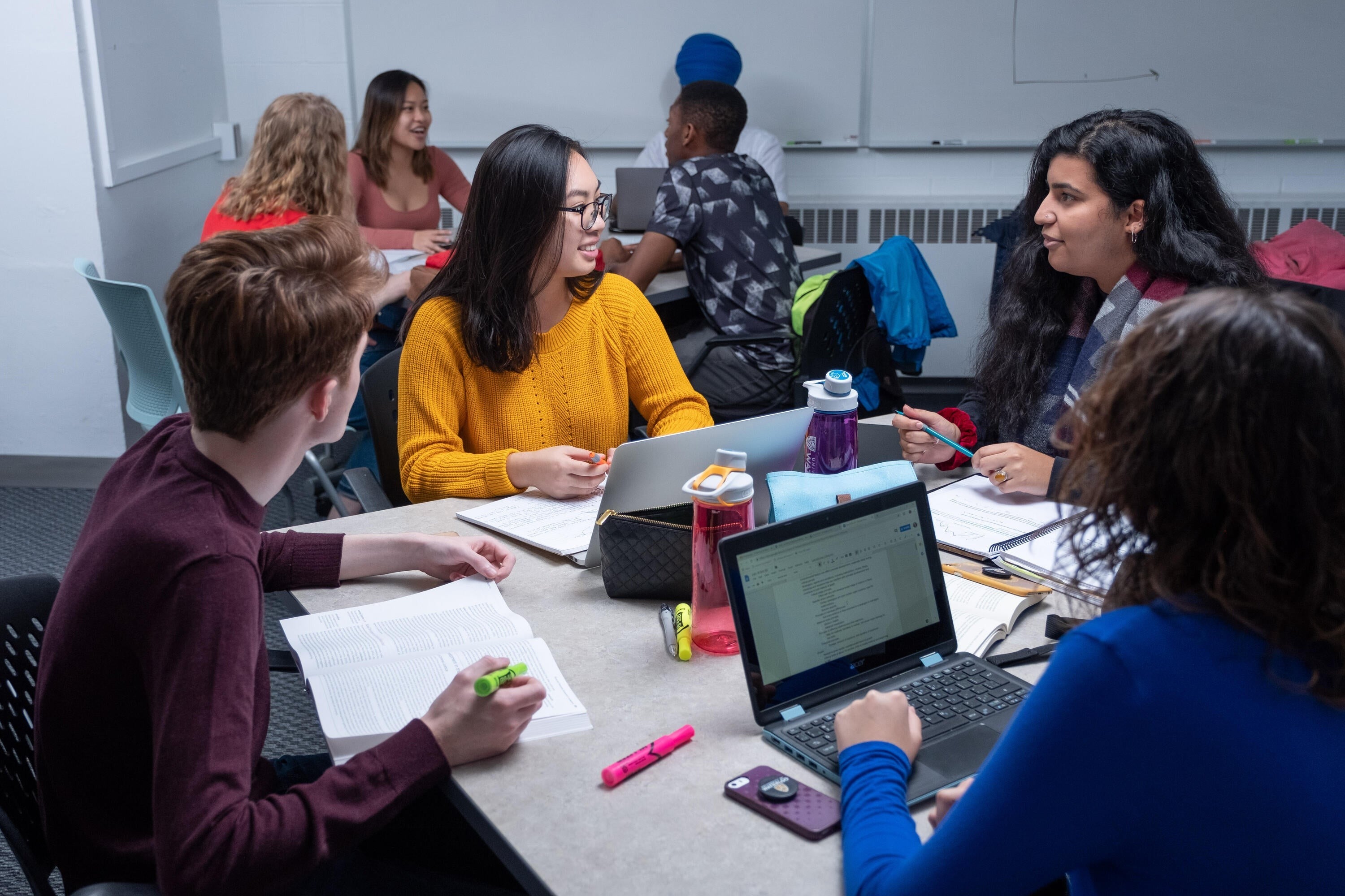Students sit around a table in discussion