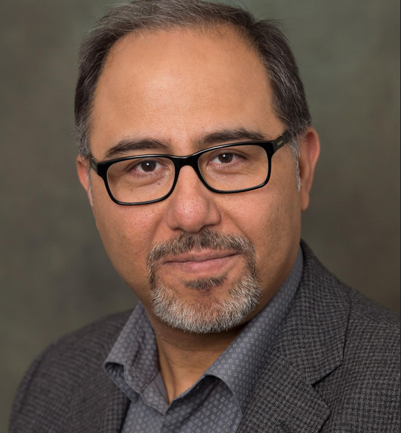 A MAN SMILING AT THE CAMERA