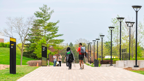 Two students walk away from camera on a UWaterloo path