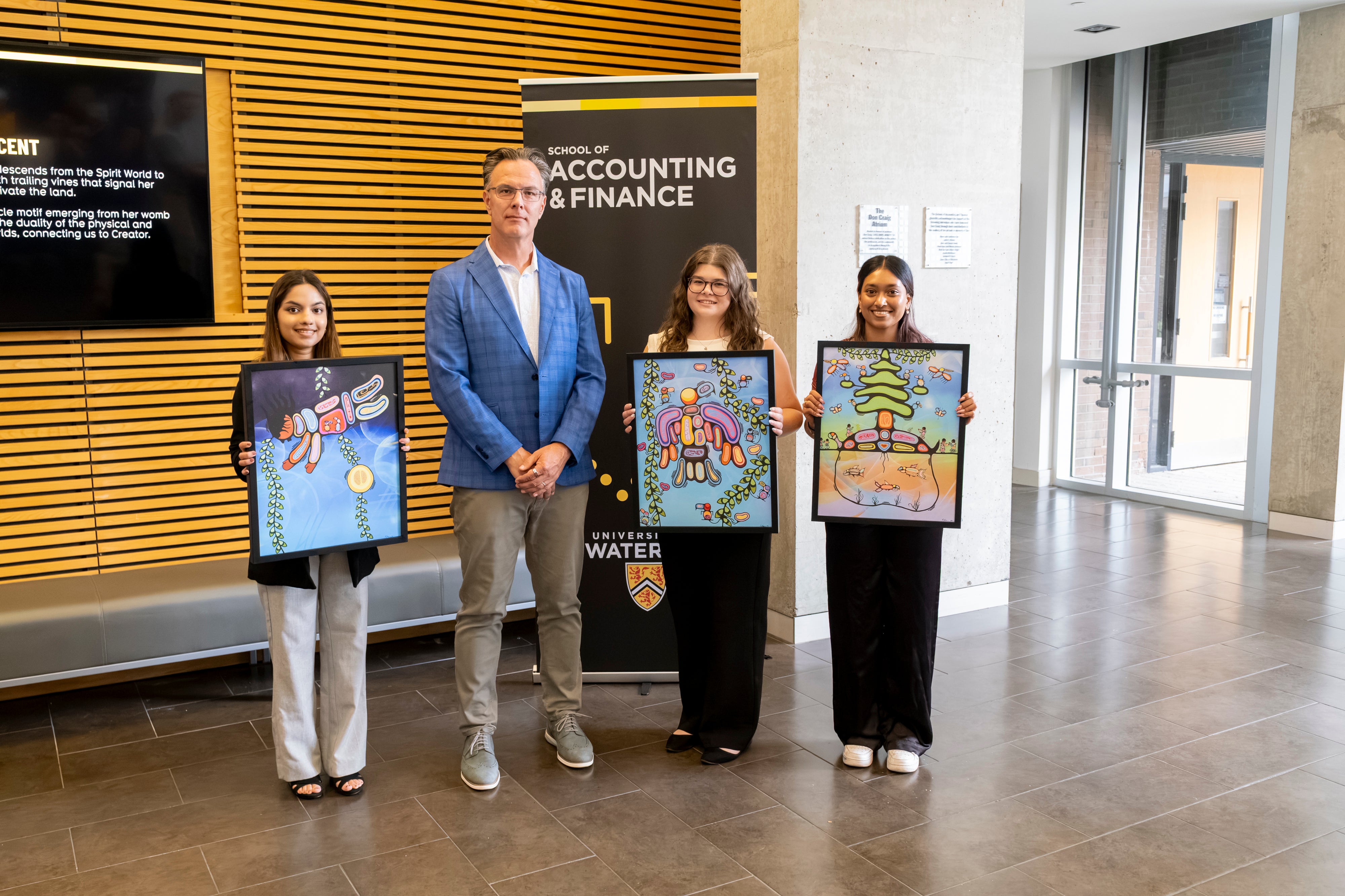 Dr. Blake Phillips with students holding paintings