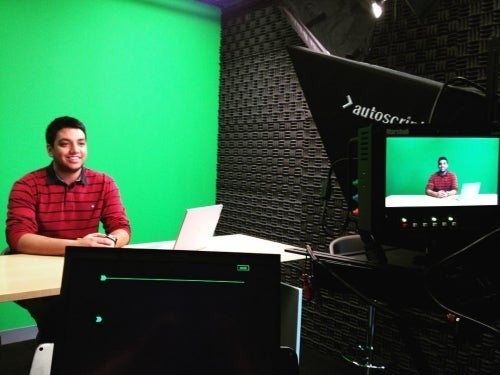 Chirag Sheth sitting in front of a green screen and a video camera.