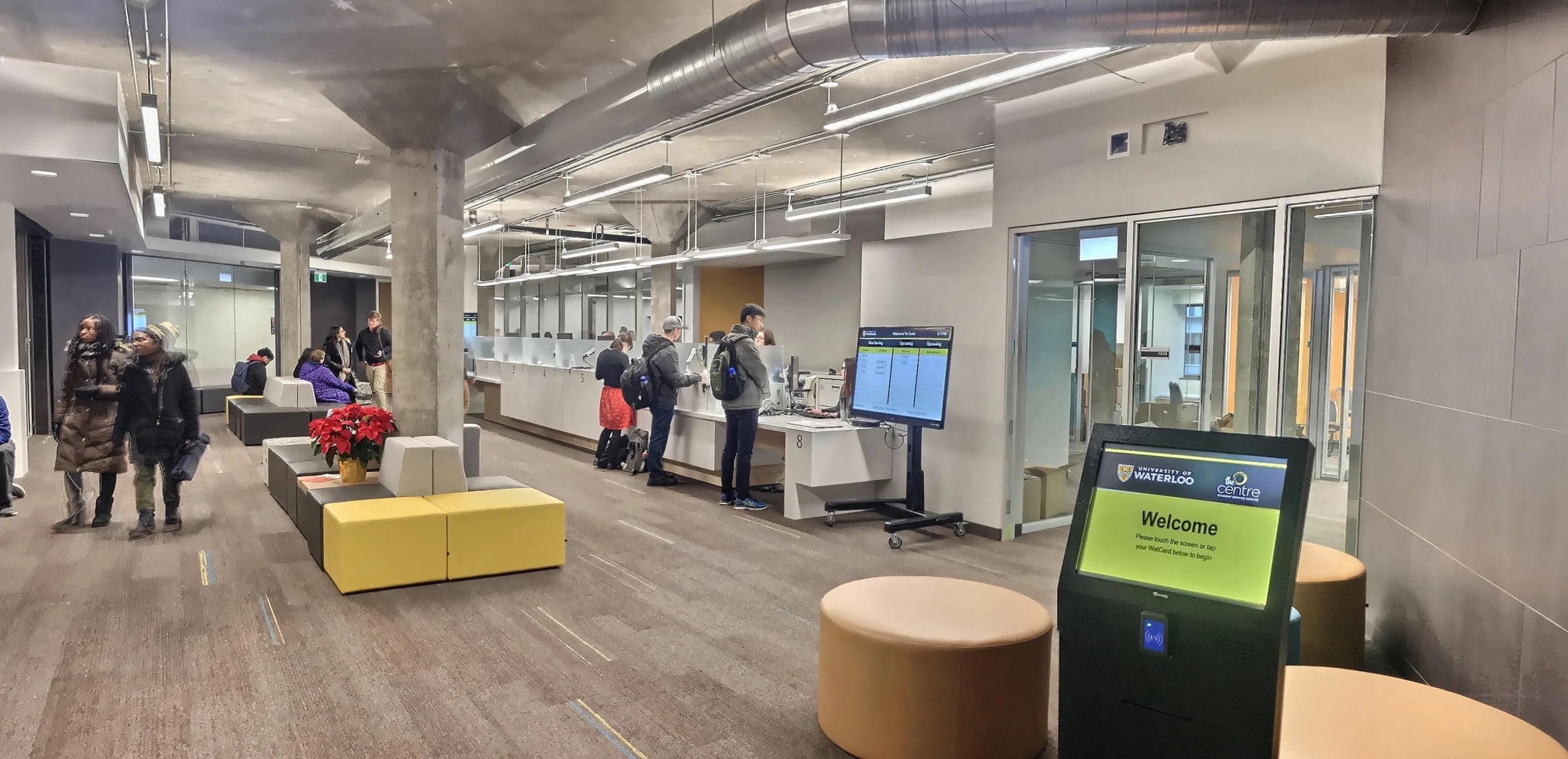  students at service wicket, walking through lobby, and sitting