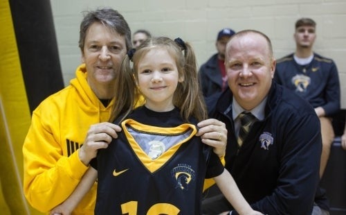 Varsity Basketball picture of a little girl and two men in the picture