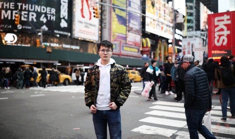 Student Haonan Duan poses at a busy intersection