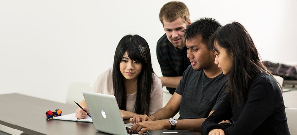 A group of students working on a laptop