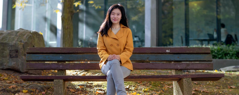 Professor Xiao Hu on a bench in Waterloo's rock garden