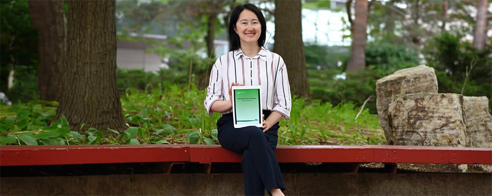 photo of Professor Xi He with her book, Differential Privacy for Databases