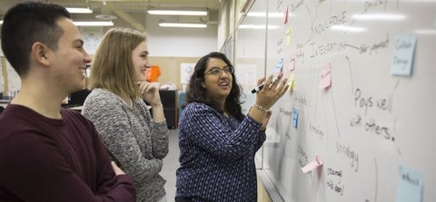 Students brainstorming on a whiteboard.