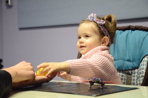 Little girl sharing toy