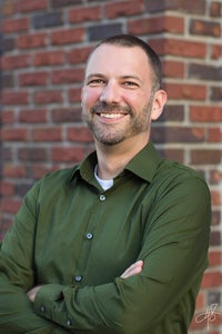 Chris Friend standing in front of a brick wall