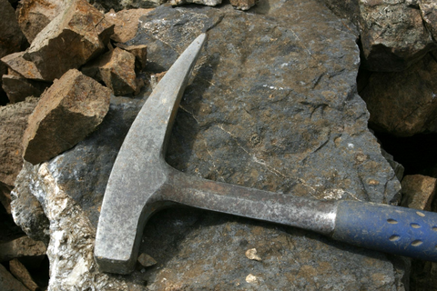Geological hammer on top of a rock specimen.
