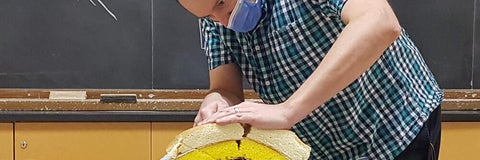 Man cutting cake meant to look like tectonic plates.