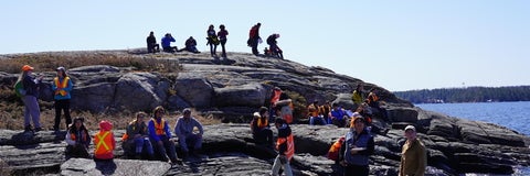 Students on a geologic field trip examining an outcrop.