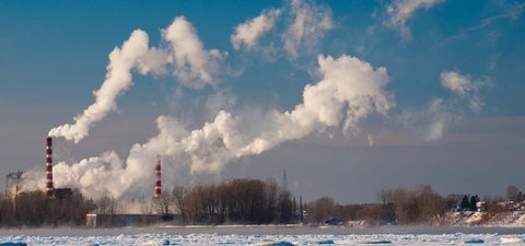 Landscape of factories and their white cloud emissions.