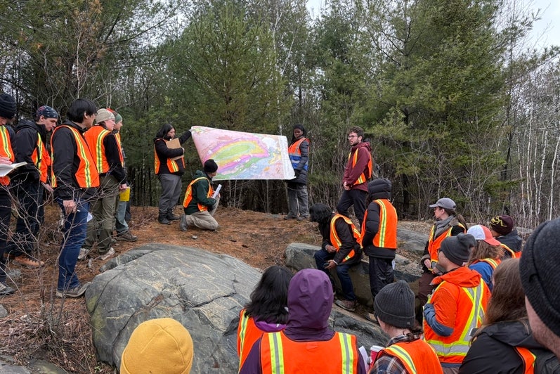 A group of students studying a map on a field trip.