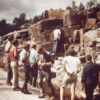 A group of Earth Science students stand next to rock wall. 