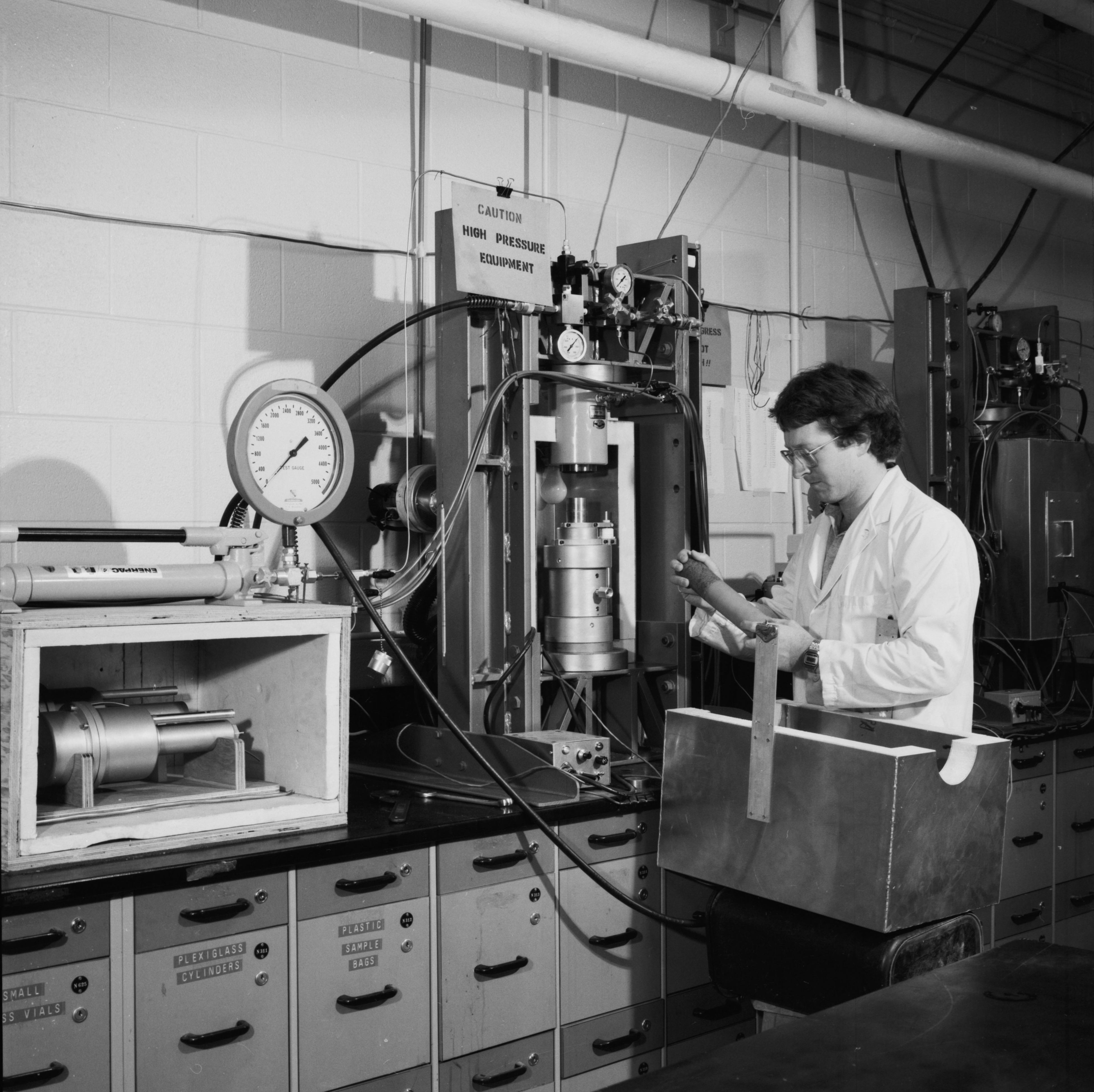 A man in a lab coat in an Earth Sciences lab. 