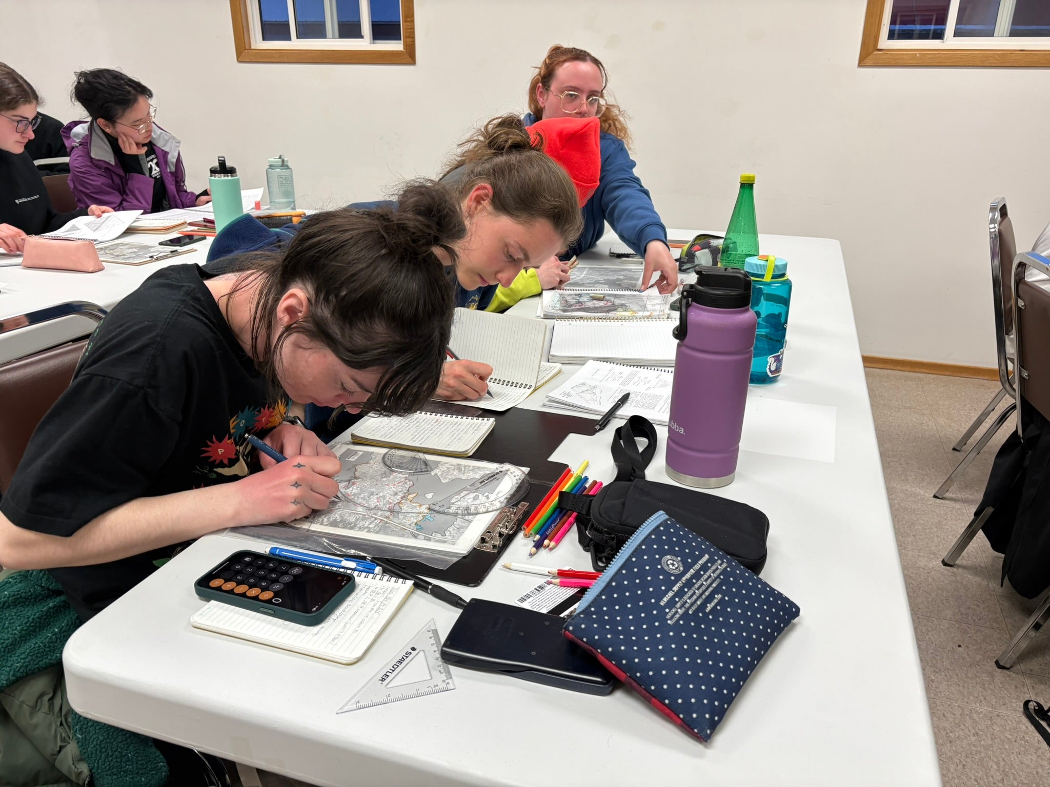 Students at a table working on maps. 