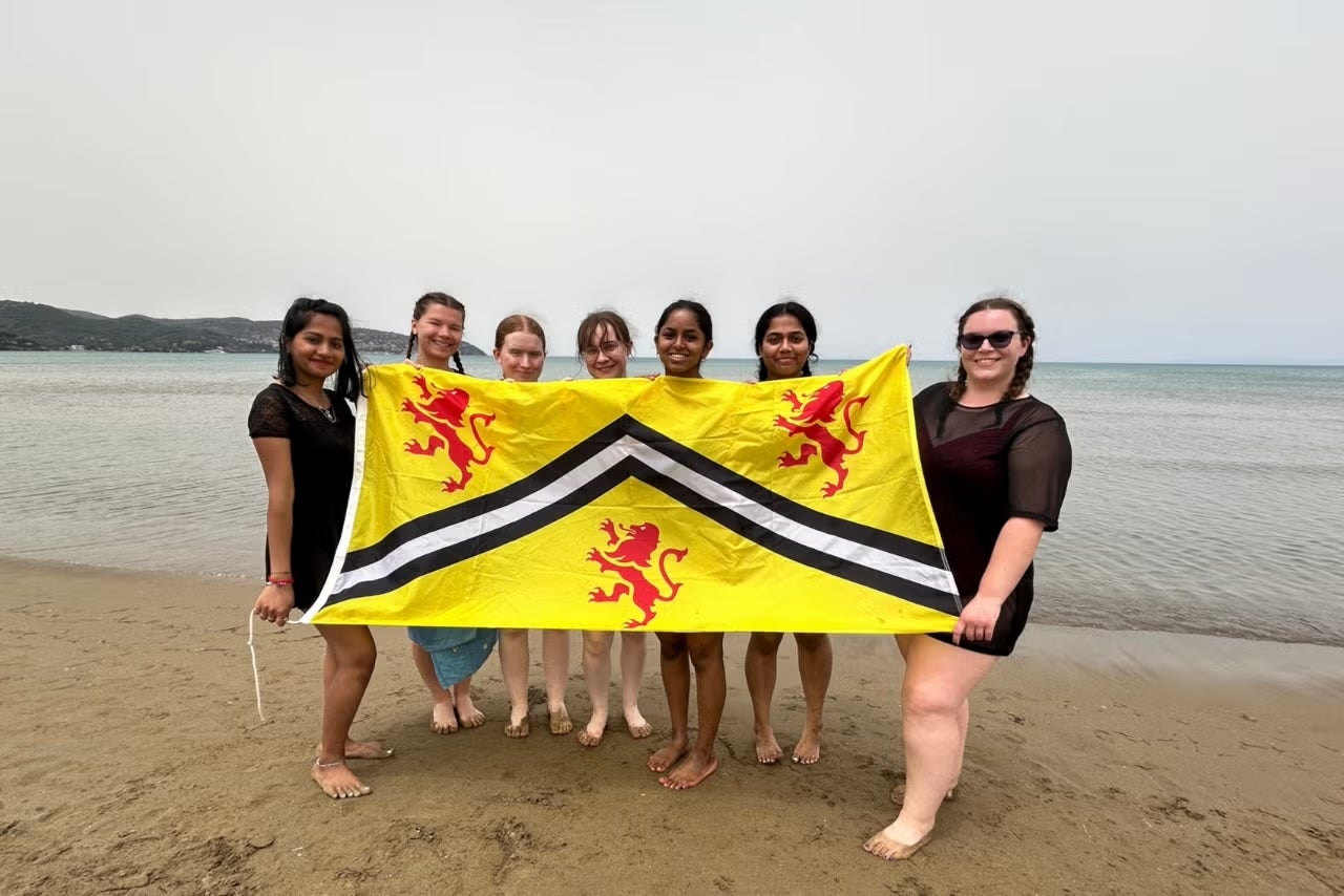 Students holding the University of Waterloo flag. 