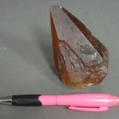 Calcite showen to be half the size of a pen for size comparison