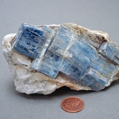 Kyanite next to a penny for size comparison