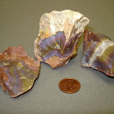 Rainbow Agate next to a penny for size comparison