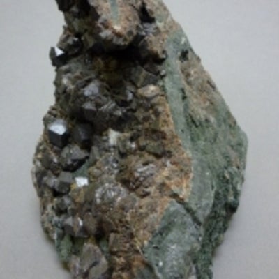 Andradite next to a penny for size comparison