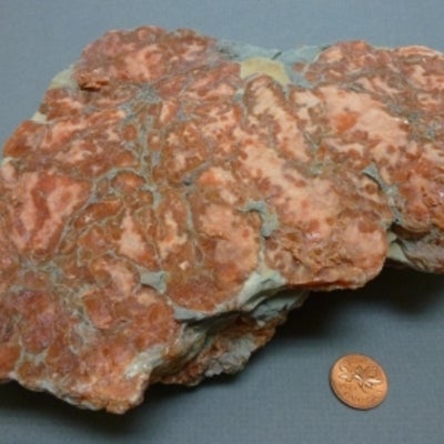 Copper-colour Gypsum next to a penny for size comparison
