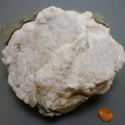 Gypsum next to a penny for size comparison