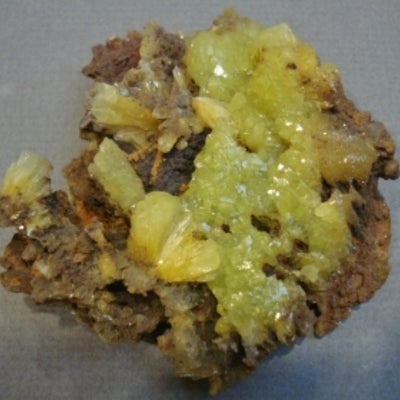 Yellow- green coloured mineral with brown rock or mineral