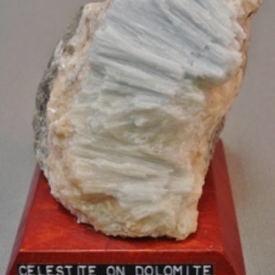 Celestite on dolomite mounted on a wood base with a label
