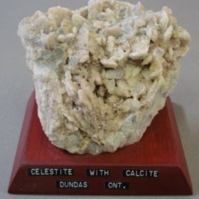 Celestite with calcite mounted on a wood base with a label