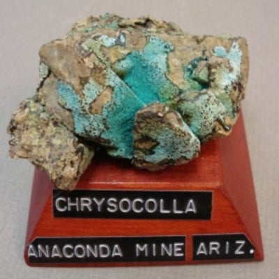 Chrysocolla mounted on a wood base with a label
