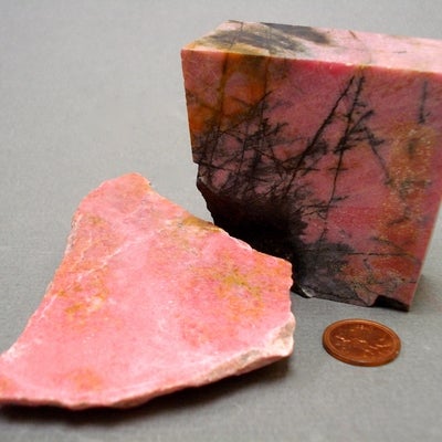 Rhodonite next to a penny for size comparison