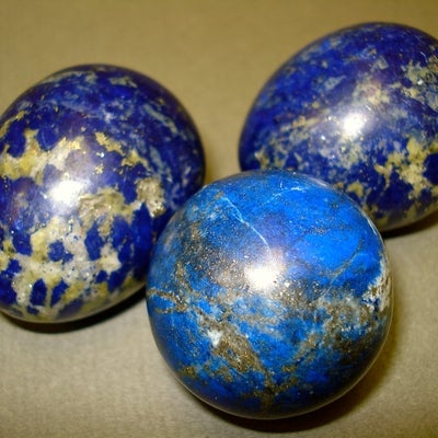 Lapis Lazuli Eggs and Sphere next to a penny for size comparison