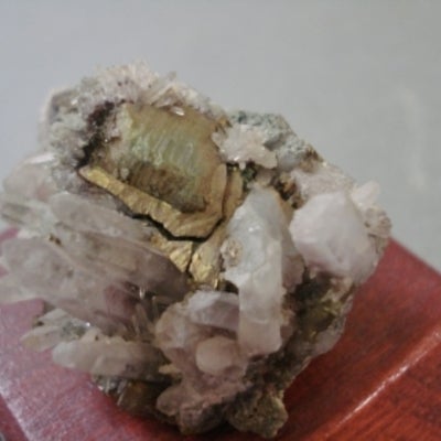 Quartz and pyrite mounted on a wood base with a label