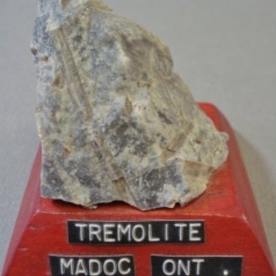 Tremolite mounted on a wood base with a label