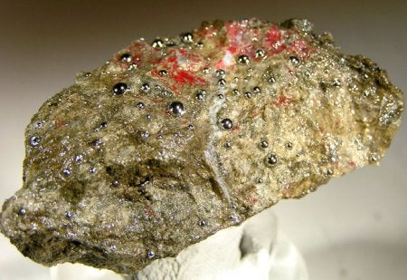 beads of liquid mercury in cinnabar rock