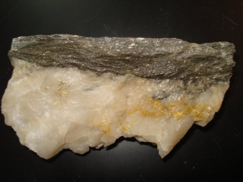 slight speckling of white quartz with metallic brown-yellow metal