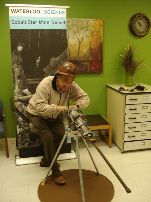 man standing with drill on stand pretending to operate drill