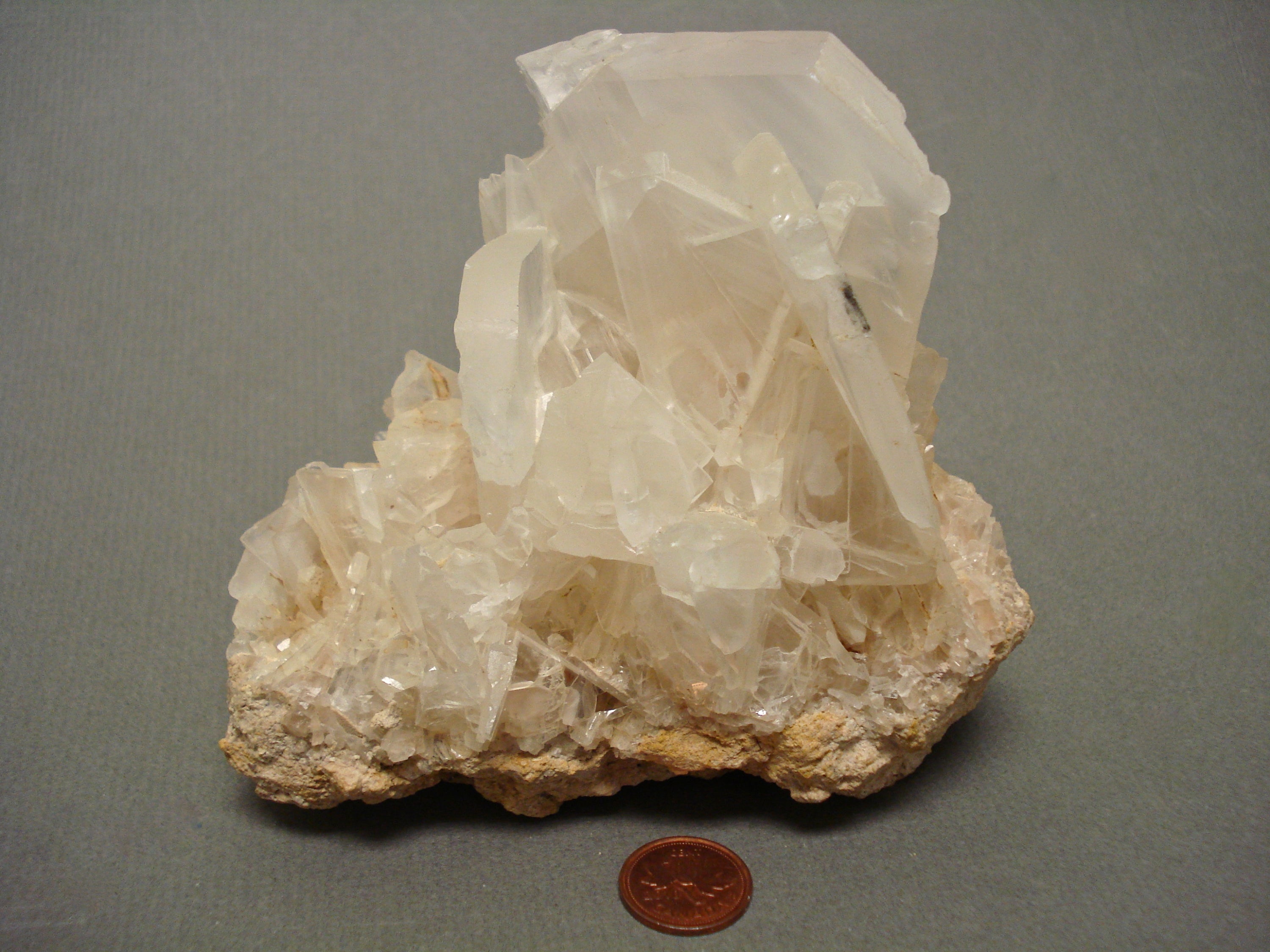 Calcite next to a penny for size comparison