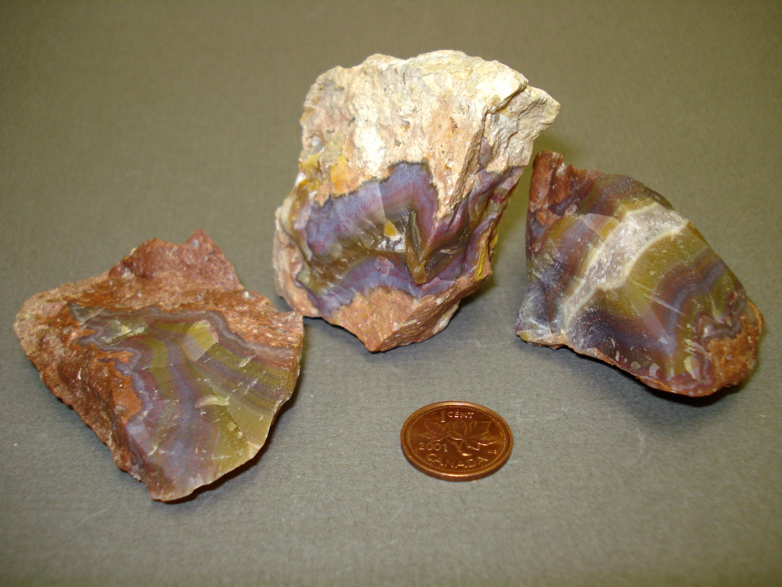Rainbow Agate next to a penny for size comparison