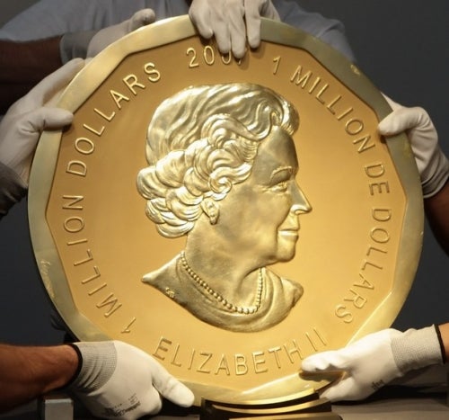 5 hands belonging to 3 people holding giant gold coin