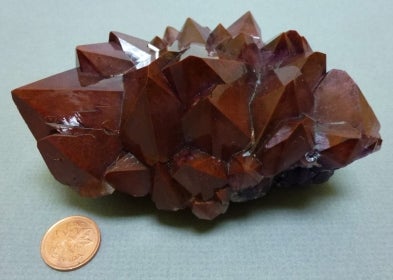 Amethyst next to a penny for size comparison.
