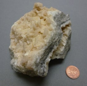 dolomite next to a penny for size comparison