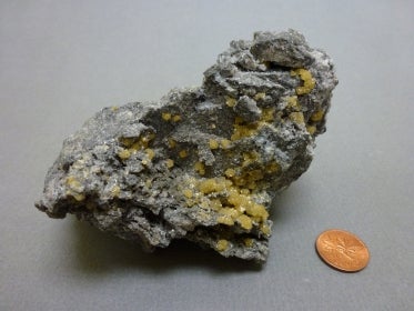 Sphalerite next to a penny for size comparison