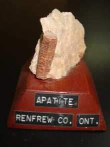 pink apatite specimen mounted on wood